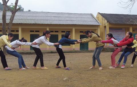 Children play tug with an object. 